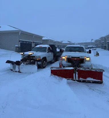 Two snow removal trucks with snow plows
